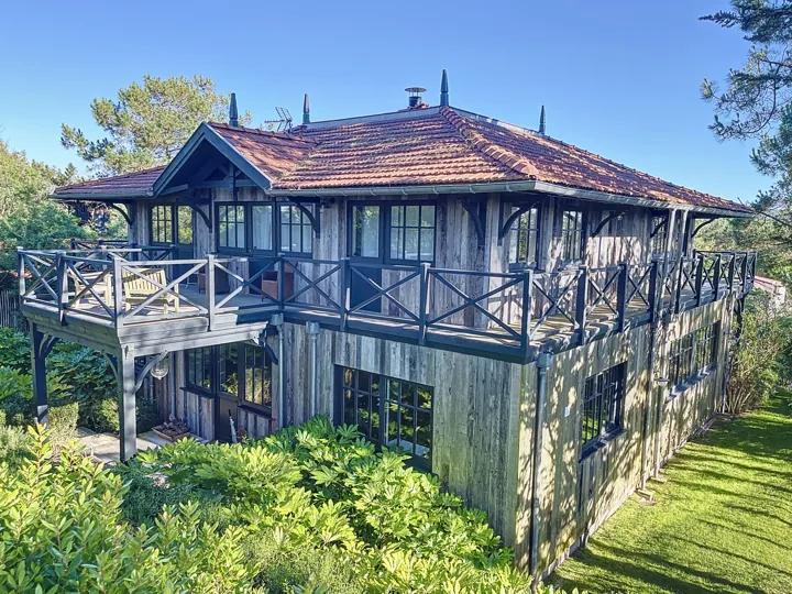 Maison en bois surélevée au milieu des arbres